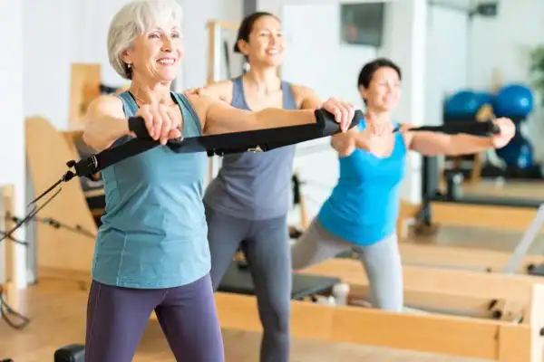Toning Arms After 60: Empowering Womens Fitness Through Effective Weight Training 2 older woman doing weight training Newark-on-Trent and resistance in the gym to tone upper arms